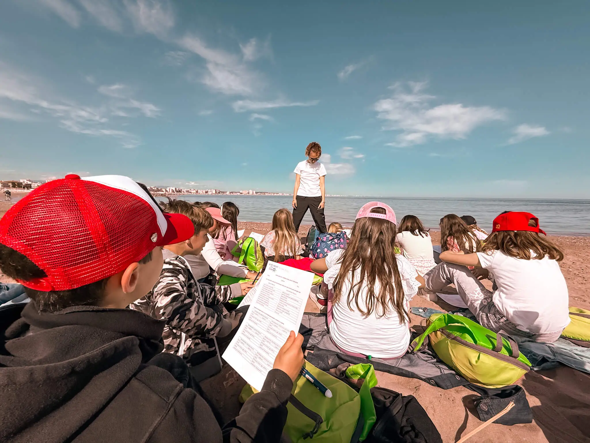 Armati di schede per registrare i ritrovamenti, spazzolini, calibri e una guida visiva dei molluschi marini, i bambini si lanciano alla ricerca di bivalvi e gasteropodi.